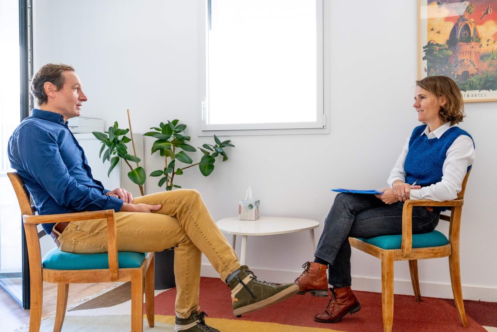 Juliette Marret, kinésiologue à Nantes, en échange avec un client dans son cabinet chaleureux et confidentiel