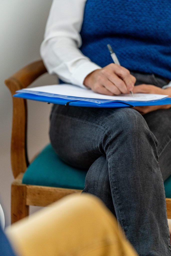 Juliette Marret, kinésiologue à Nantes, prenant des notes sur ses genoux pendant une séance